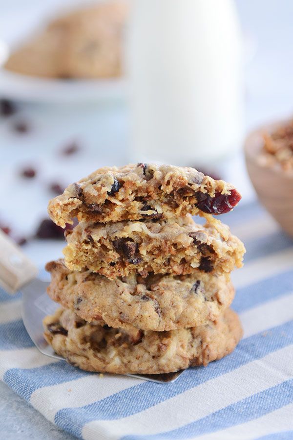 a stack of cookies sitting on top of a blue and white table cloth next to a glass of milk