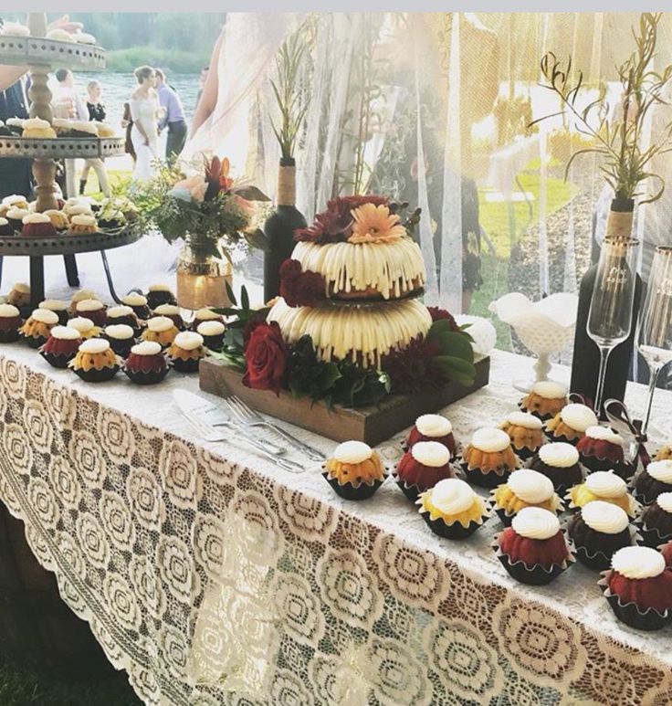 a table topped with lots of cupcakes and cakes