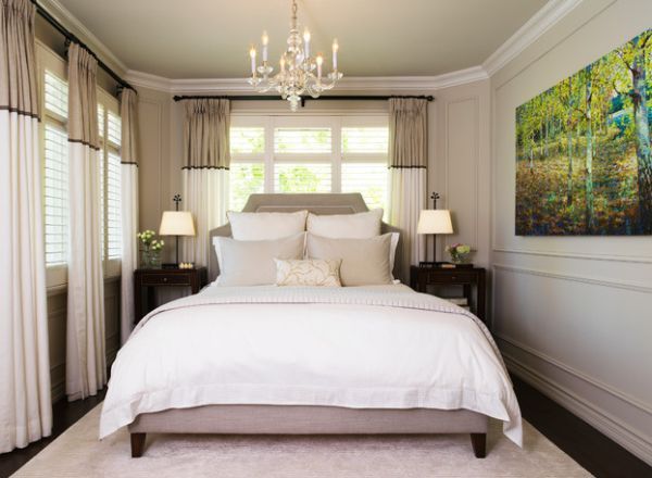 a bedroom with a bed, chandelier and two lamps on the nightstands