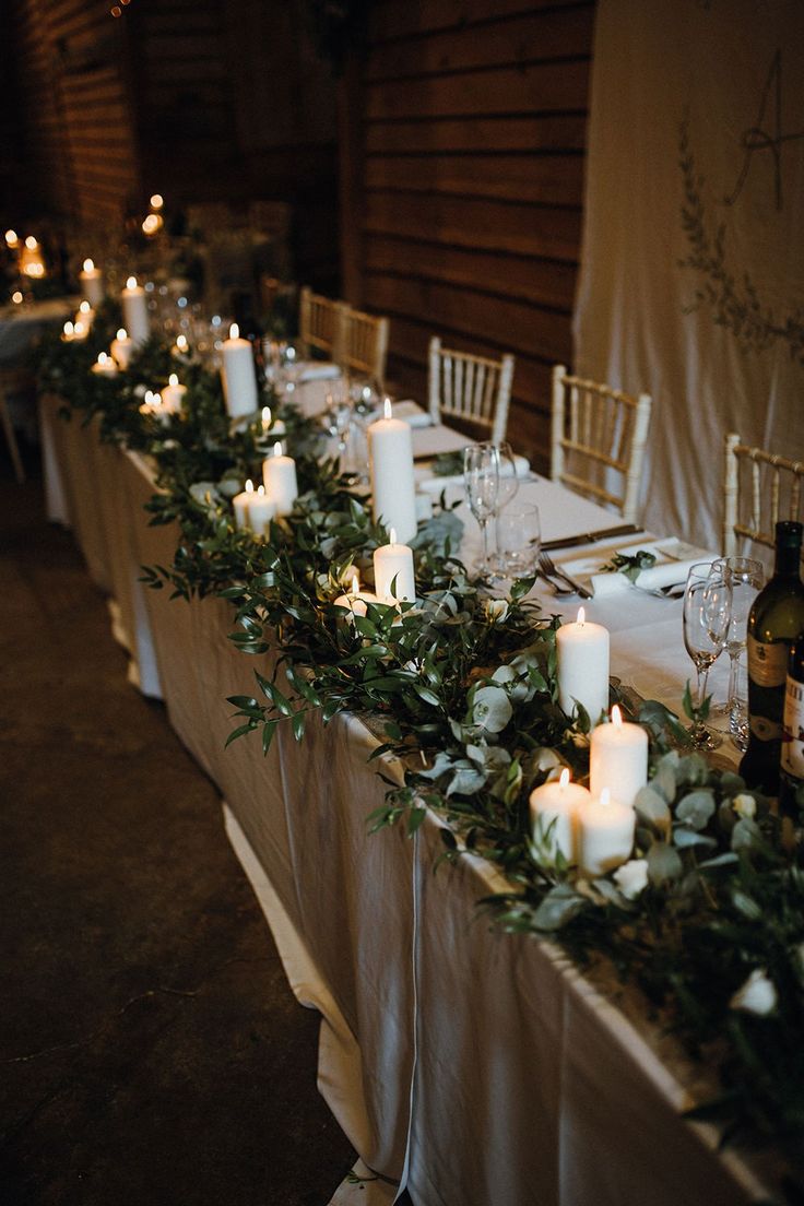 the table is set with candles and greenery