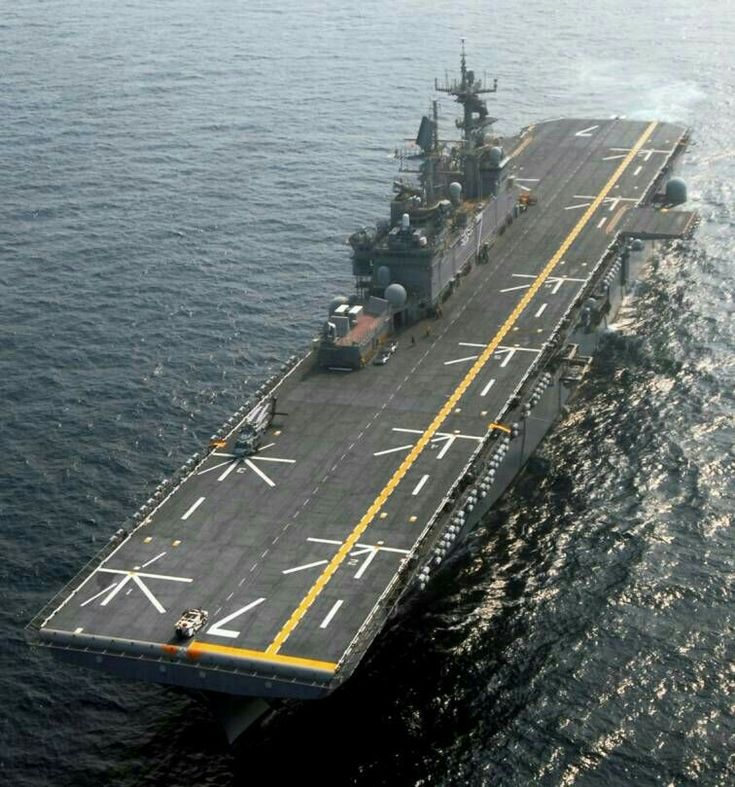 an aircraft carrier floating in the ocean on top of it's flight deck,