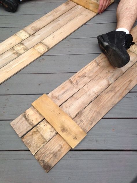 a person sitting on top of wooden planks with their feet propped against one another