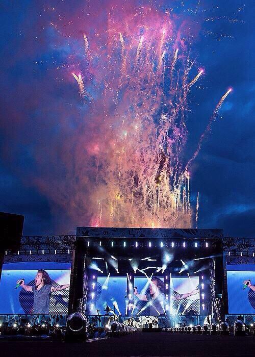 fireworks are lit up in the sky above a stage