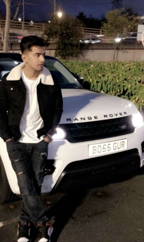 a man standing next to a white car