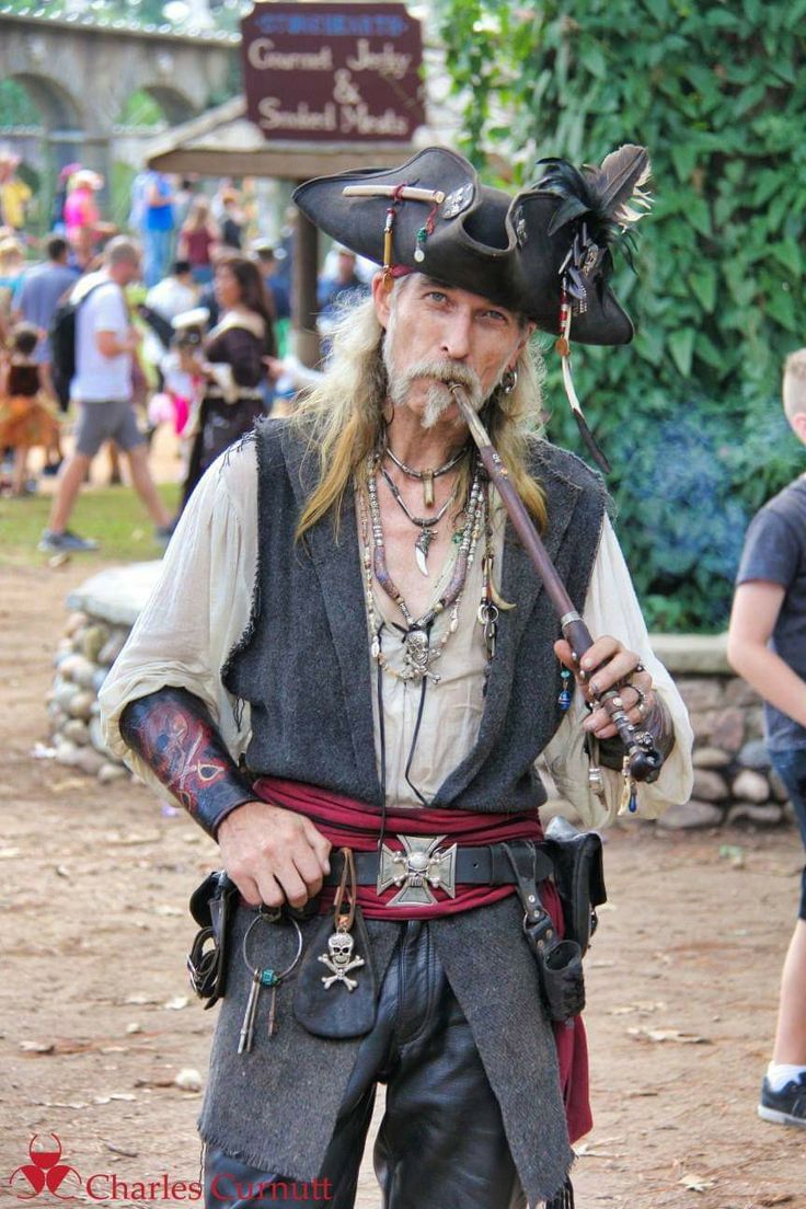 a man dressed as captain jack sparrow with a pipe in his mouth and pirate hat