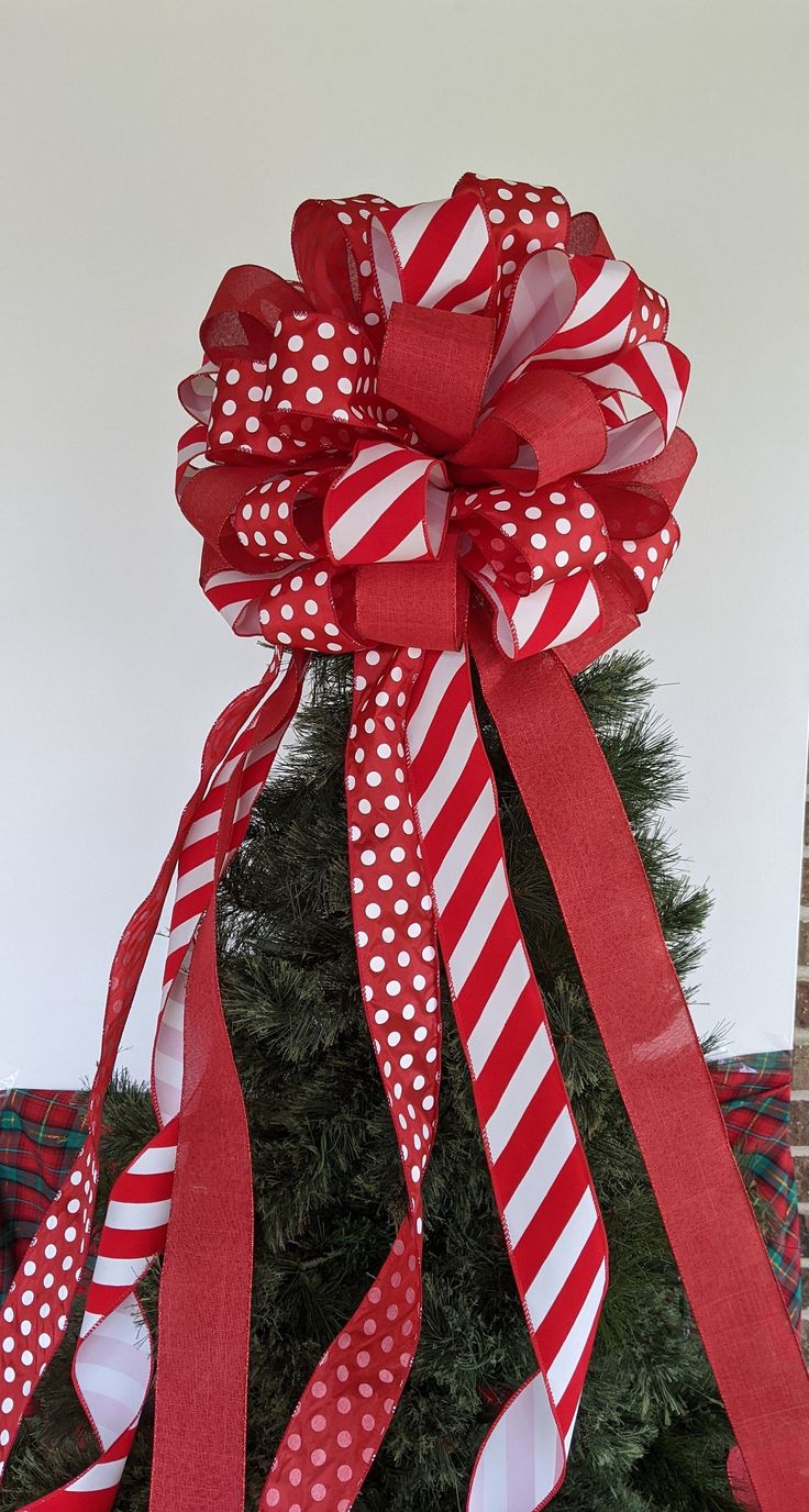 a christmas tree with red and white ribbons