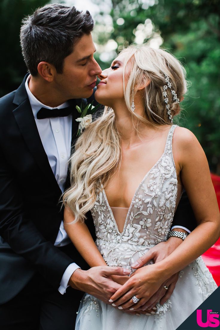 a man in a tuxedo kissing a woman in a wedding dress and holding her