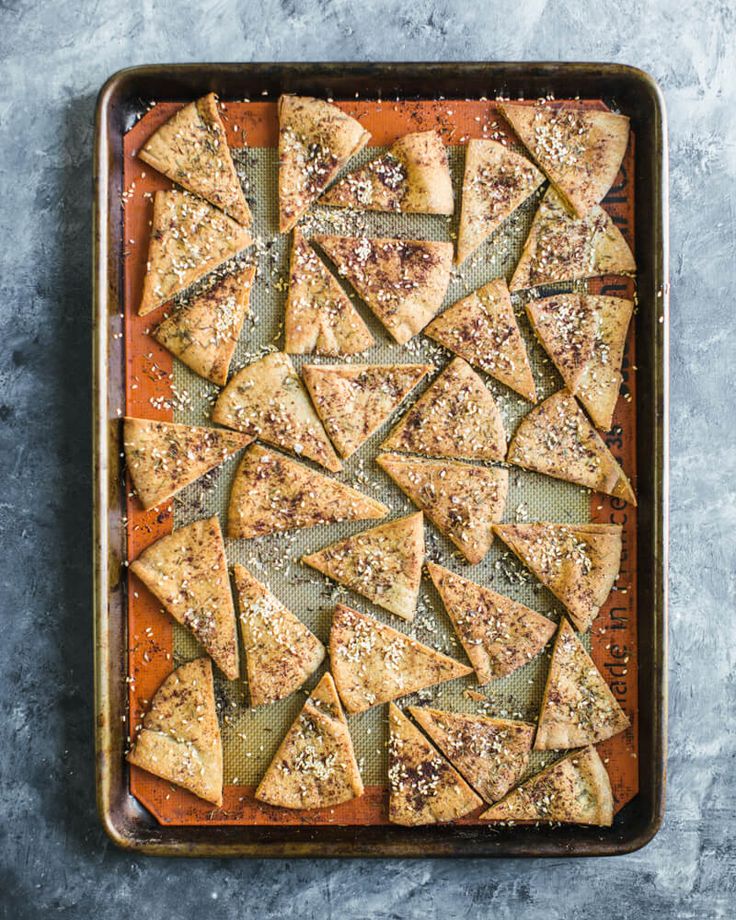 a pan filled with sliced up pizza on top of a table