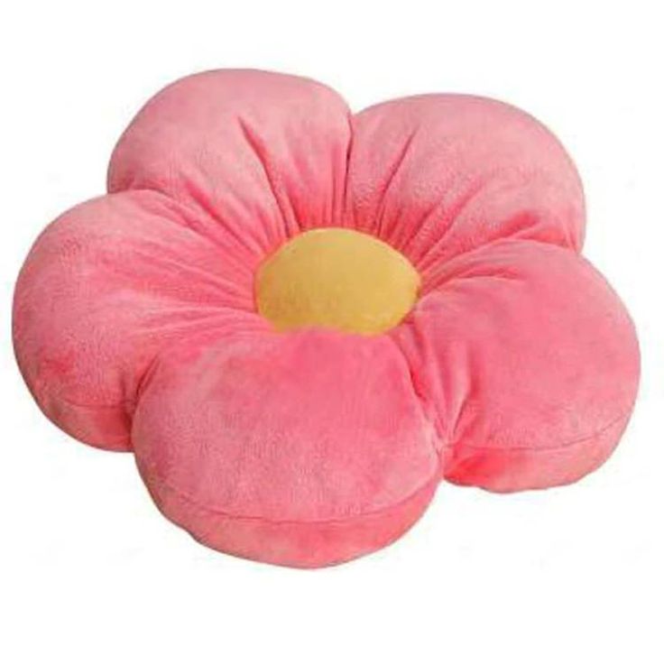 a pink flower shaped pillow sitting on top of a white surface with a yellow center