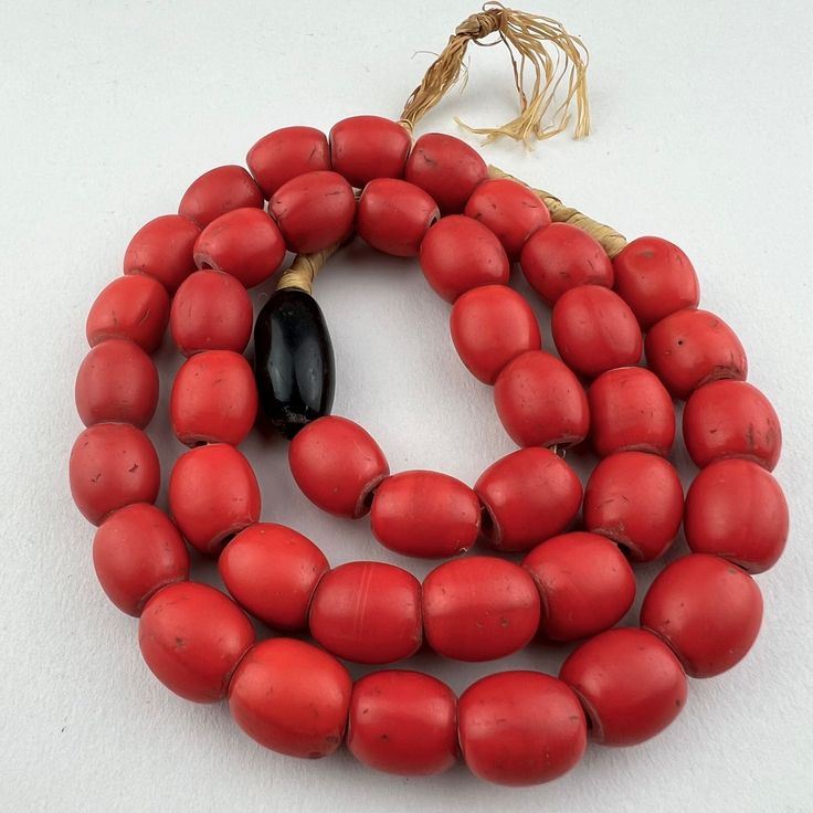 A strand of old tomato red Bohemian Colondente beads made in the late 1800's or early 1900's and traded to Ethiopia. Worn satin smooth and in good condition.  40 beads 22 1/2" of beads 57cm 25" strand with raffia 63cm 12x12 mm on average 2mm hole Traditional Red Beaded Necklaces With Oval Beads, Traditional Red Beaded Necklace With Oval Beads, Traditional Single Strand Oval Beads, Vintage Wooden Beads, Red Wooden Beads In Traditional Style, Red Wooden Beads Traditional Style, Vintage Red Beaded Necklaces With Oval Beads, Red Traditional Wooden Beads, Red Bohemian Large Beads