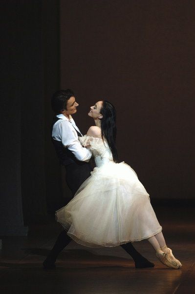 two people dressed in white are dancing together