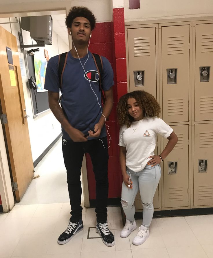 two people standing next to each other in front of lockers with headphones on