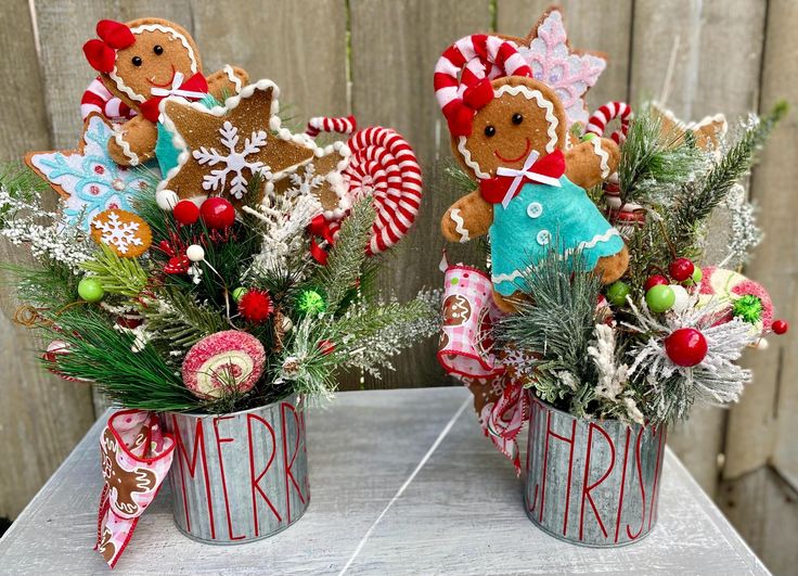 two tin cans filled with christmas decorations on top of a table