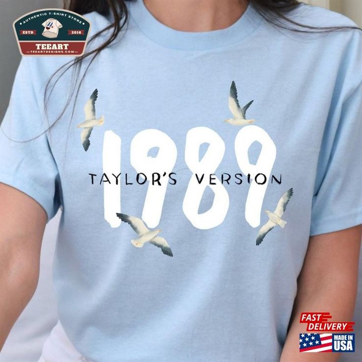 a woman wearing a t - shirt with the words 1989 printed on it and birds flying around her