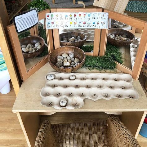 a wooden table topped with lots of bowls filled with rocks and grass on top of it