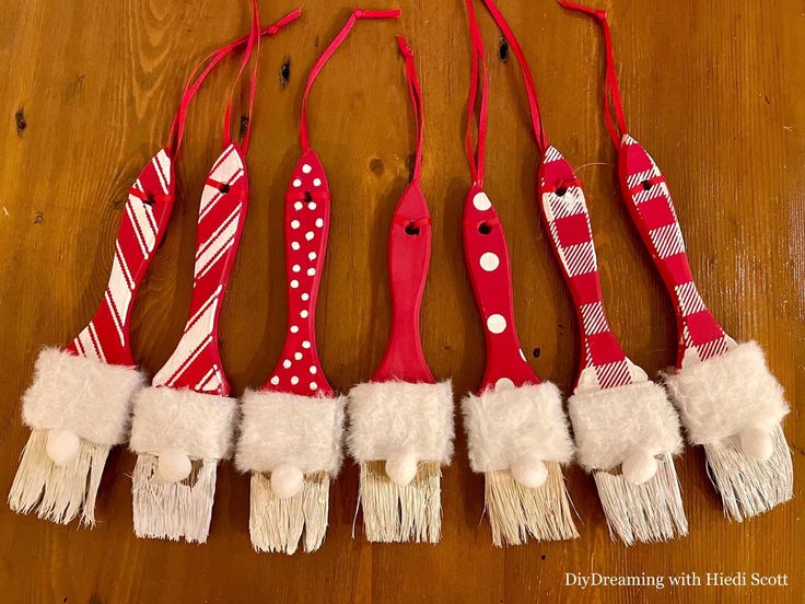 five red and white toothbrushes lined up next to each other on a wooden table