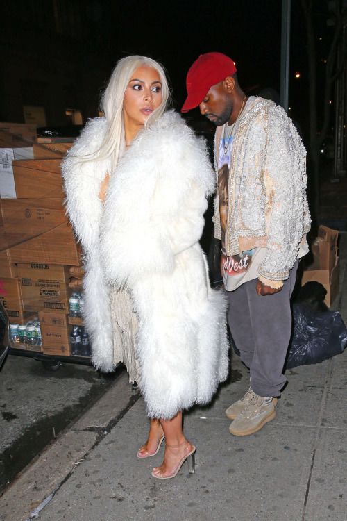 a man standing next to a woman in a fur coat