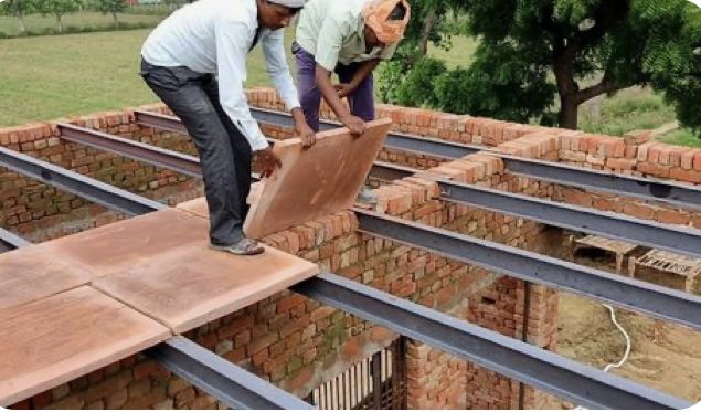 two men are working on the roof of a building that is being built with red bricks