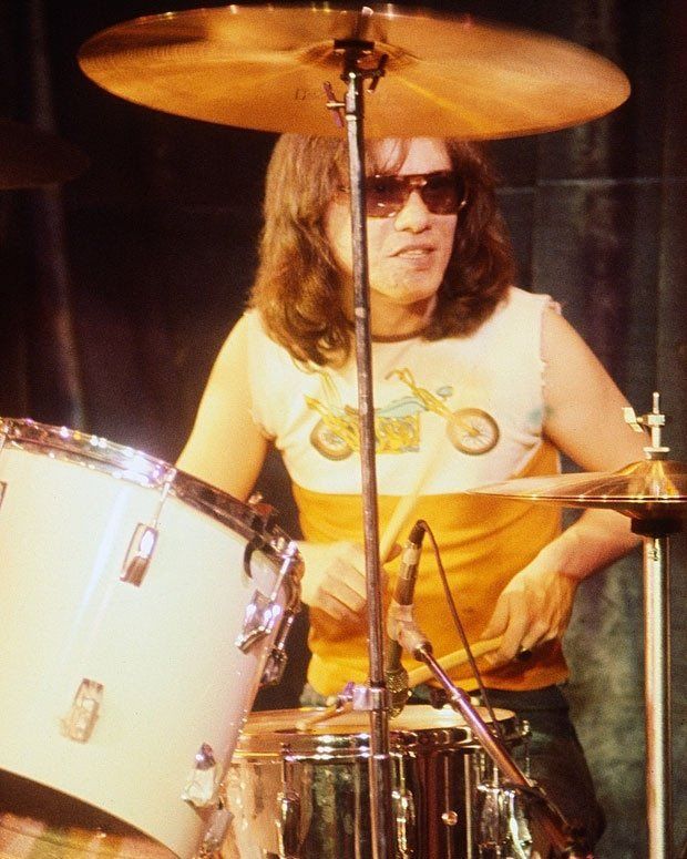 a man playing drums in front of a drum set