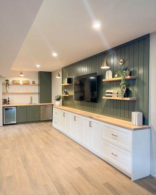 an empty kitchen with wooden floors and green walls