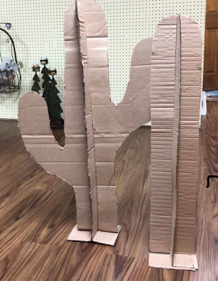 a cardboard cut out of the shape of a cactus on top of a wooden floor