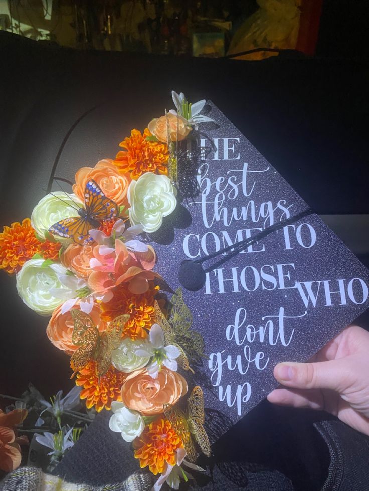 a graduation cap decorated with flowers and the words best things come to those who don't give up