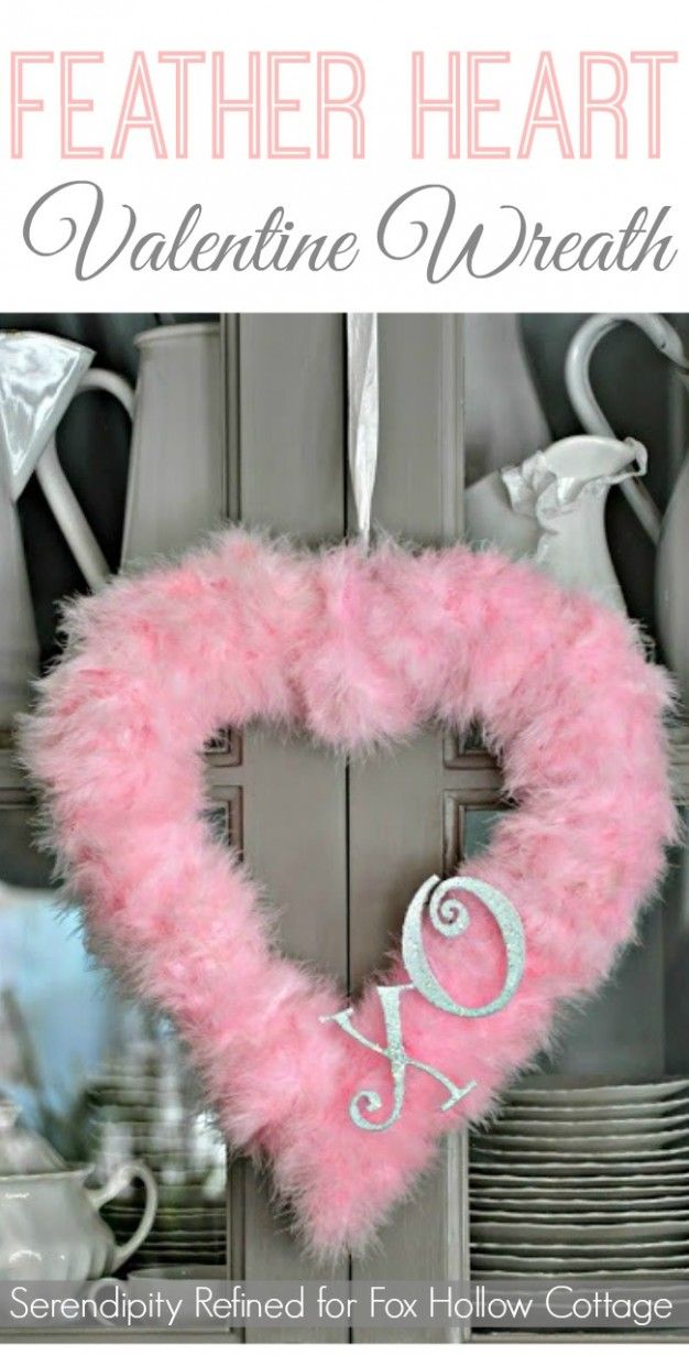 a pink heart shaped wreath hanging from the side of a door with text overlay that reads, feather heart valentine wreath