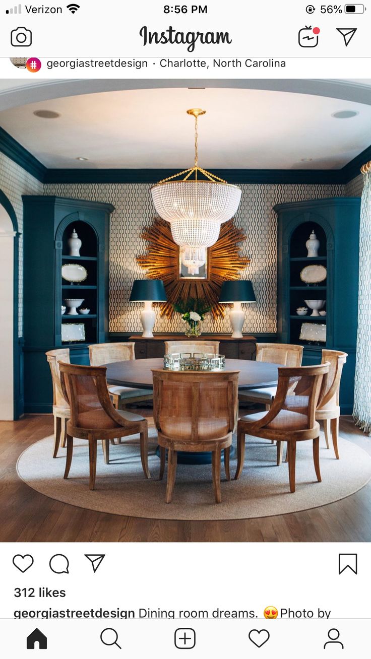 the dining room is decorated in teal and gold with blue walls, chandelier,