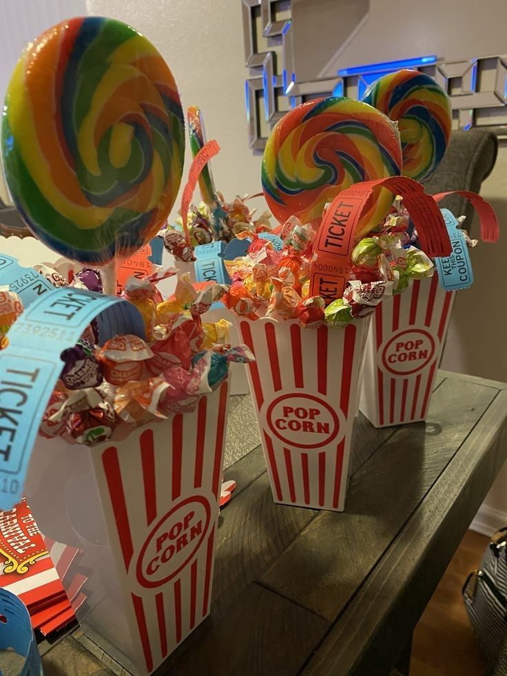 two buckets filled with candy and lollipops on top of a table