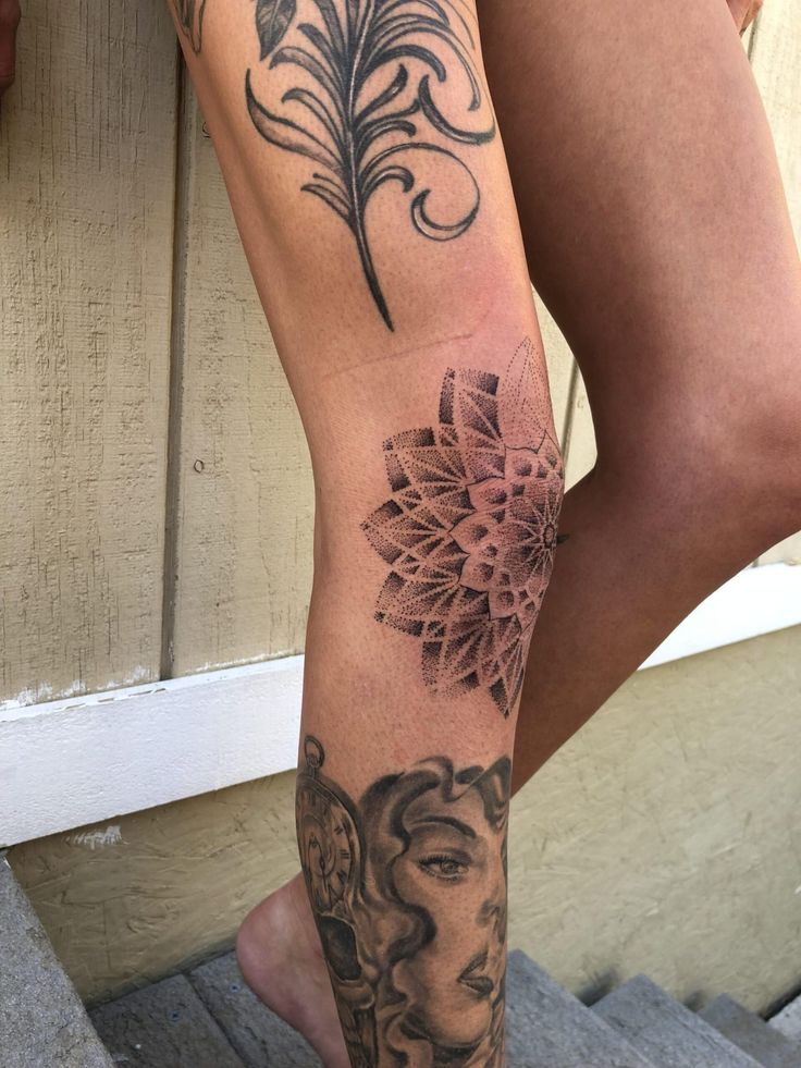 a woman's leg with tattoos on it and a flower in her left arm