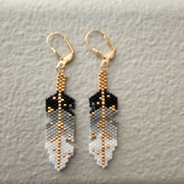 two pairs of beaded earrings with black and white feathers