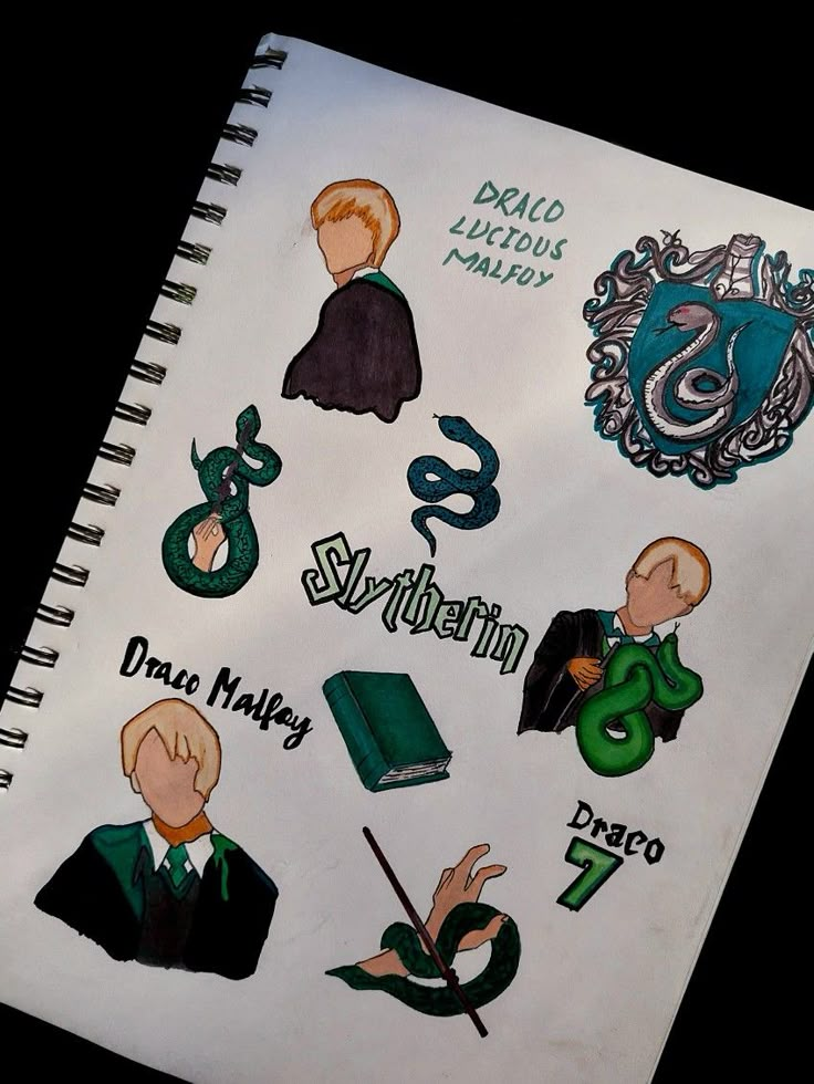 the harry potter stickers are on top of a spiral notebook with writing and symbols