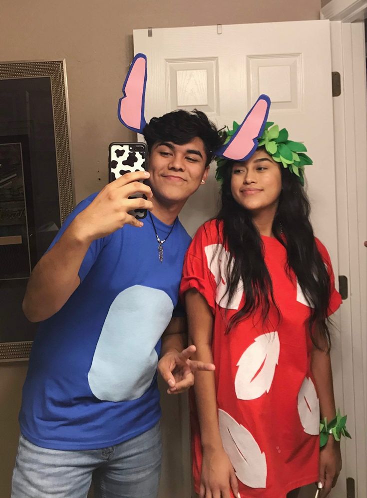 a man and woman taking a selfie in front of a door with fake antlers on their heads