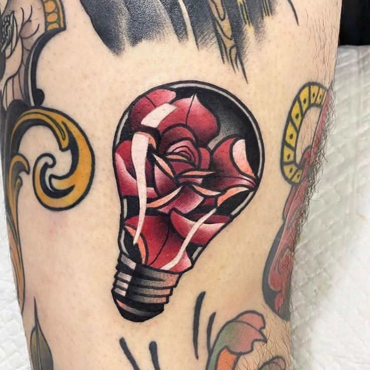 a tattoo with a light bulb and flowers on it