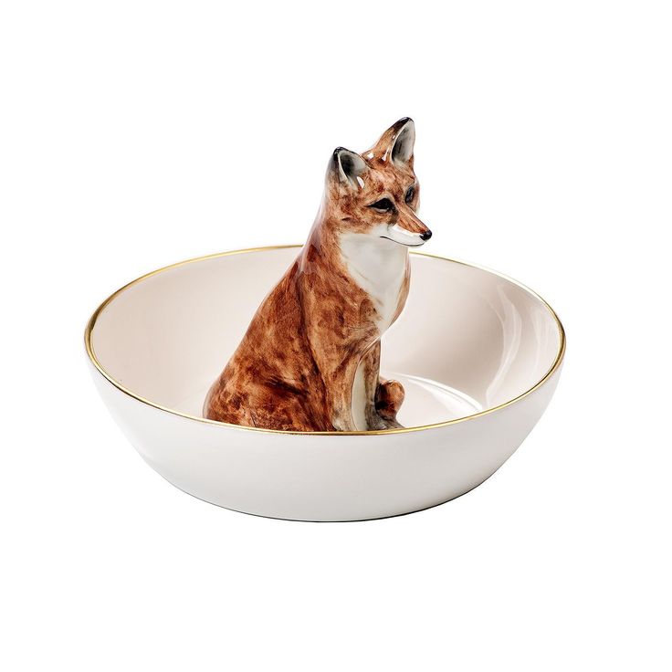 a ceramic fox sitting in a white bowl