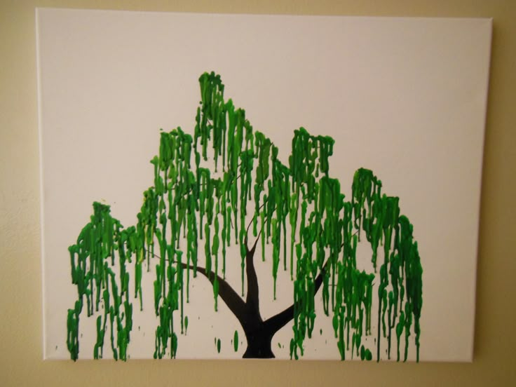 a painting of a tree with green paint dripping from it's branches on a white wall