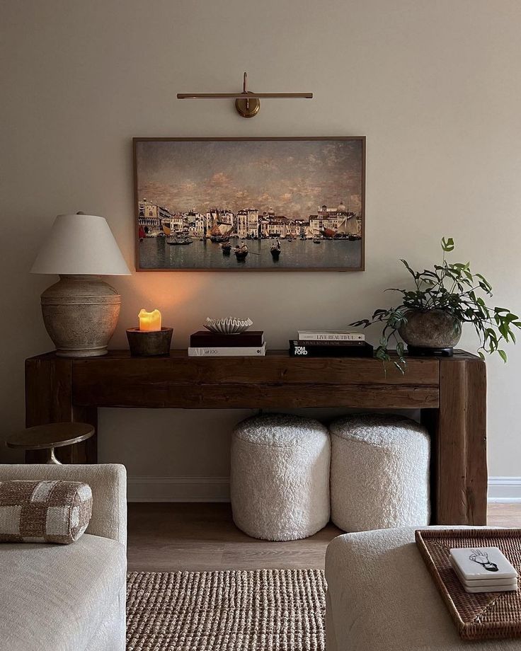 a living room filled with furniture and a painting on the wall above it's desk