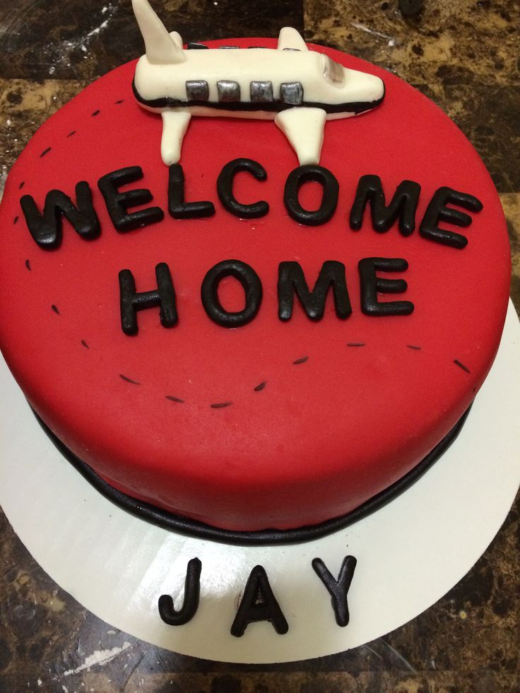 a welcome home cake with a plane on top and the words jay written in black