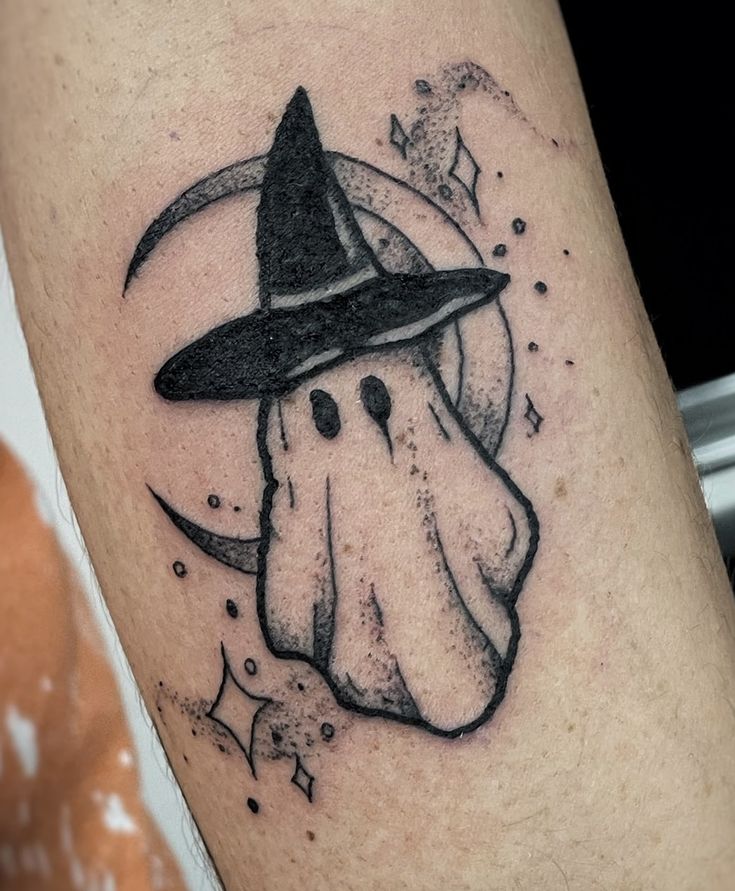 a black and white image of a ghost wearing a witches hat