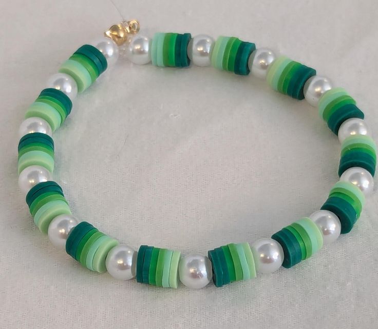 a green and white beaded bracelet with pearls