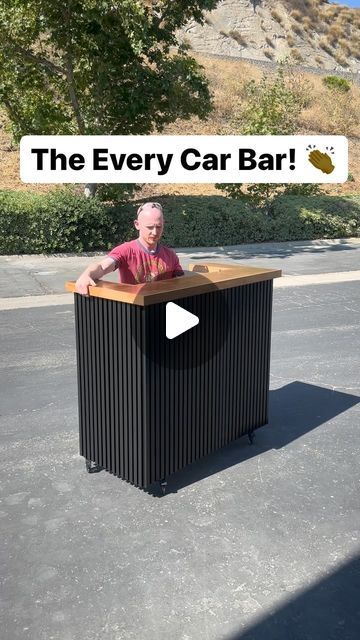 a man standing behind a black box with the words the every car bar on it