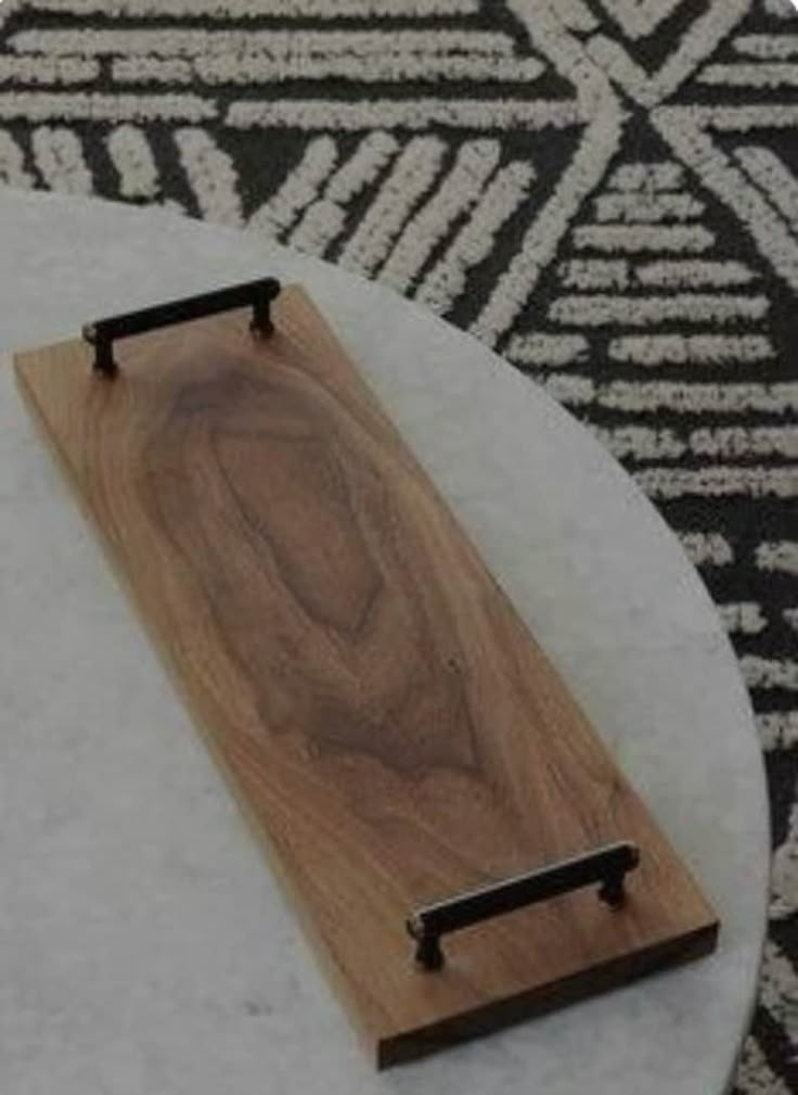 a wooden board sitting on top of a white table next to a black and white rug