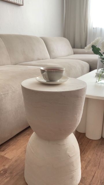 a white coffee table sitting on top of a hard wood floor next to a couch