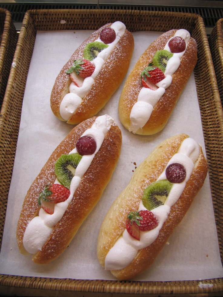 four pastries with fruit on them in a wicker basket