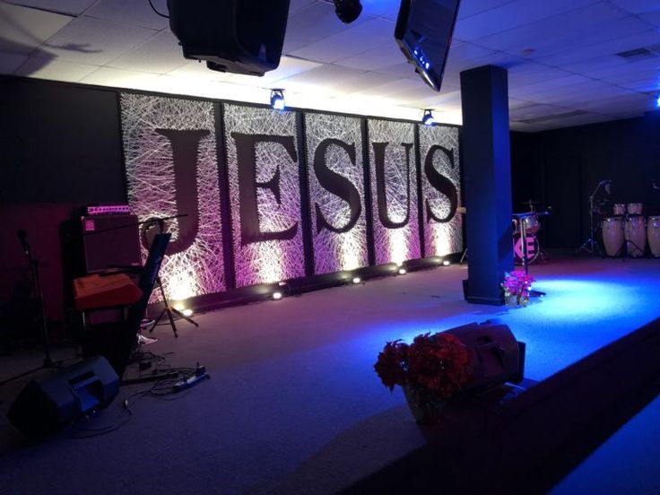 the stage is set up for an event with purple lighting and flowers on it,