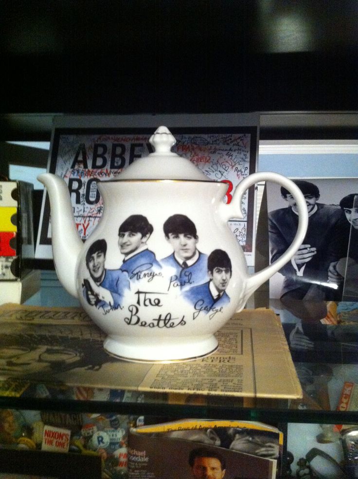 a tea pot with the beatles on it is sitting on a shelf in a store