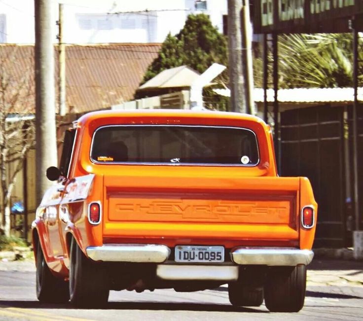 an orange truck is driving down the street