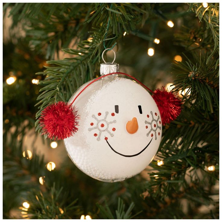 a snowman ornament hanging from a christmas tree