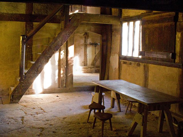 an empty room with wooden tables and stairs