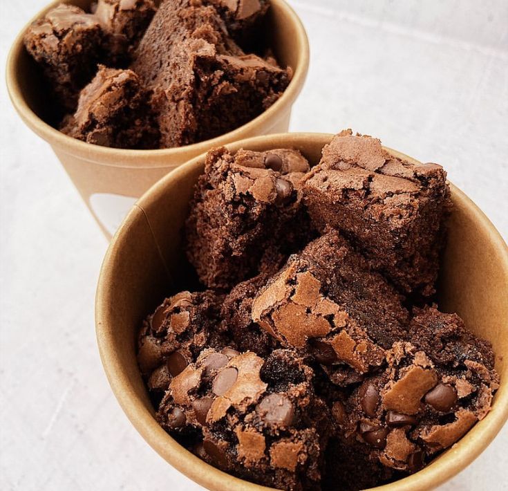 two bowls filled with chocolate brownies on top of a table